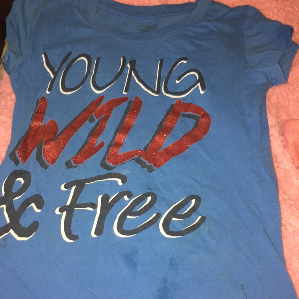 A blue shirts that says “YOUNG WILD & FREE”
